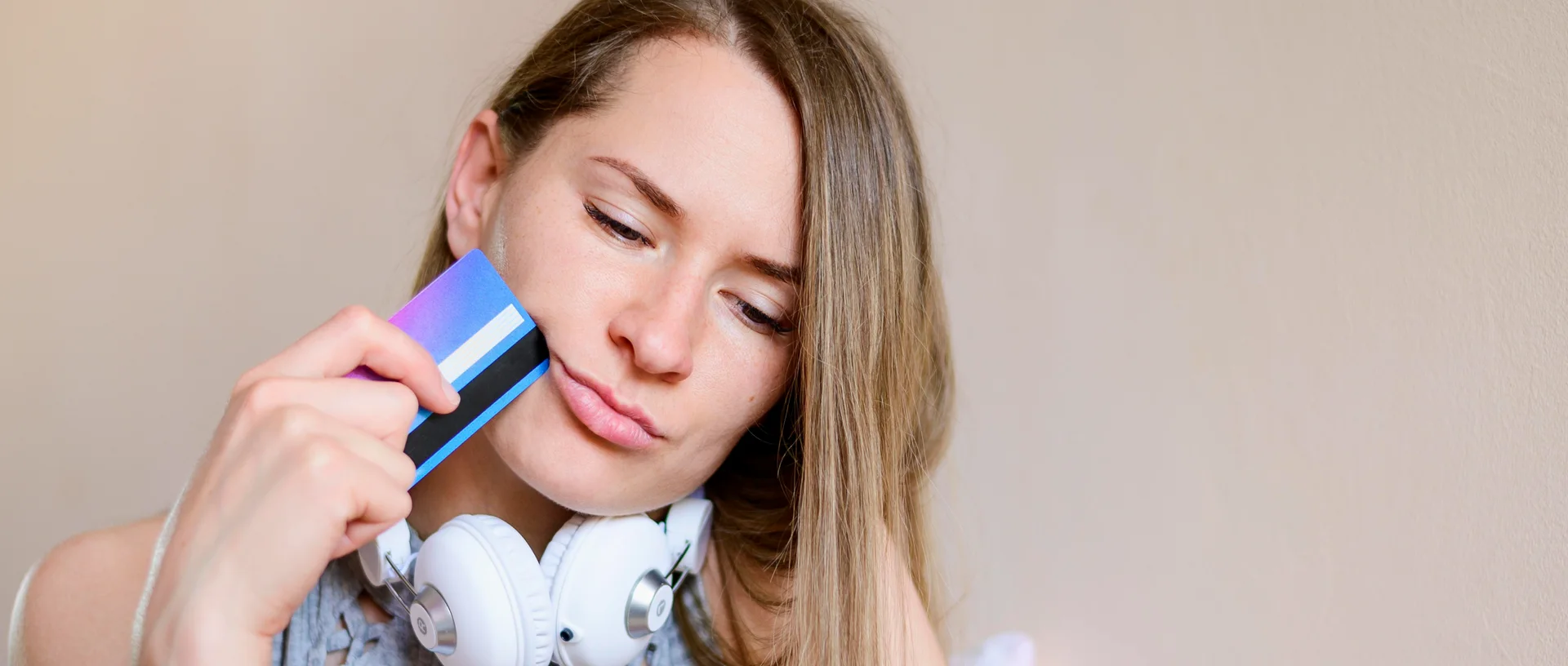 Girl holding a credit hard to her face.